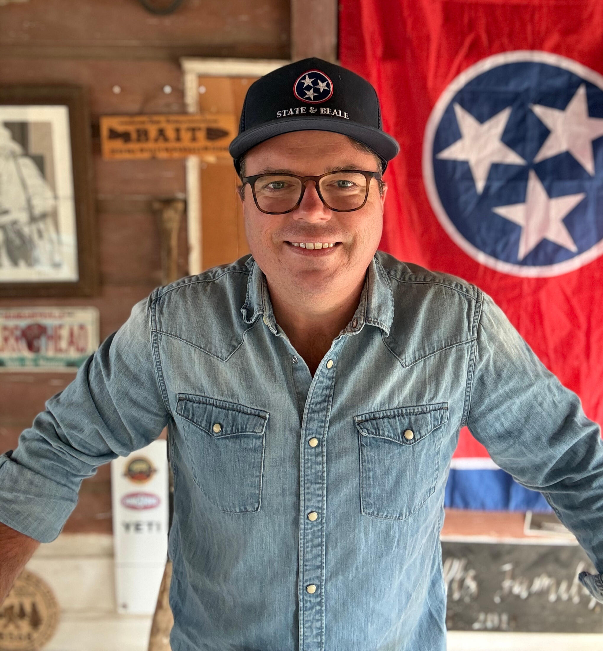 Toby Sells in a State and Beale cap in front of the Tennessee flag